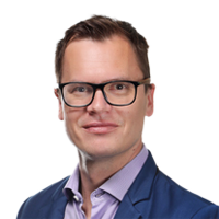 A person wearing glasses and a blue suit Description automatically generated